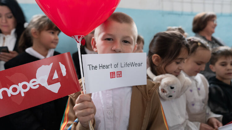Image of a child posing with a small flag that reads